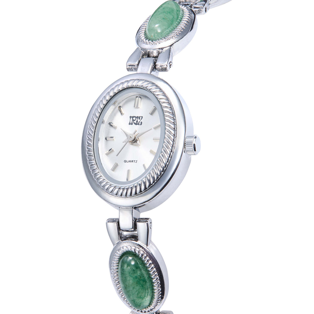 Silver watch with green gemstones in the bracelet against a white background