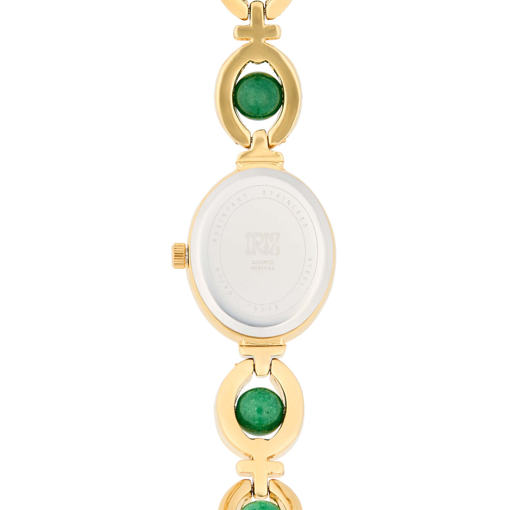 Gold watch with green gemstones in the band set against a white background